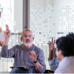 Vecinos votando a mano alzada en una junta de propietarios gestionada en Lloret de Mar.